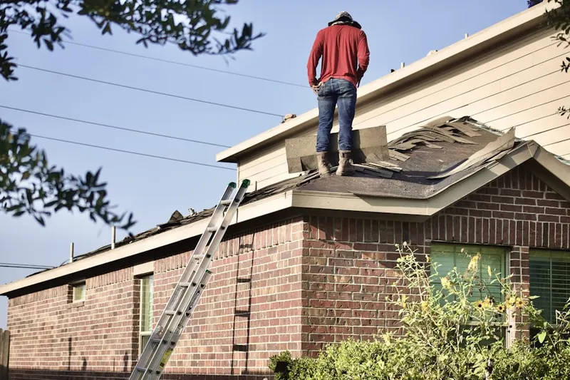 Professional roofer working on a residential roof in Emerson